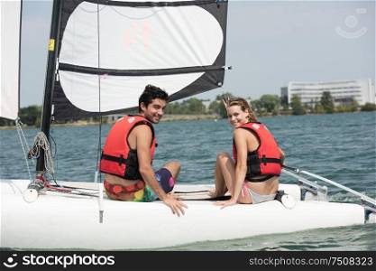 a couple is posing on the sailboat
