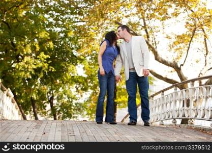 A couple kissing while walking in the park