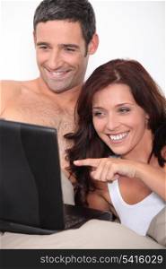 a couple laughing behind a computer