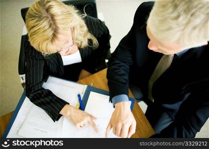 A couple (male/female) of businesspeople working on a file (very shallow depth of field)