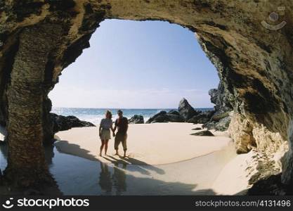 A couple observing rocks near the ocean, Natural arch, Bermuda