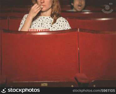 A couple of people are watching a film in a movie theater