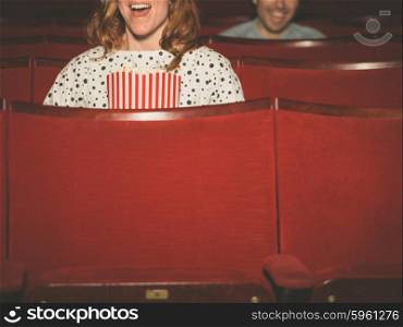 A couple of people are watching a film in a movie theater