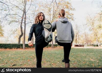 A couple of women training together outdoors in the park. A couple of women training outdoors in the park