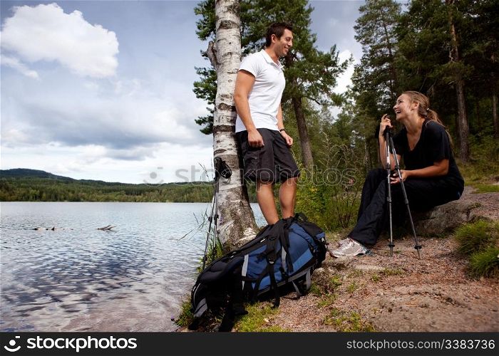 A couple on a camping trip - taking a break by a lake