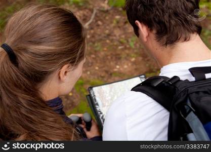 A couple orienteering with a map while camping