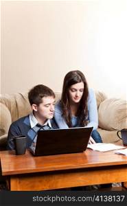 A couple paying bills by using online banking at home