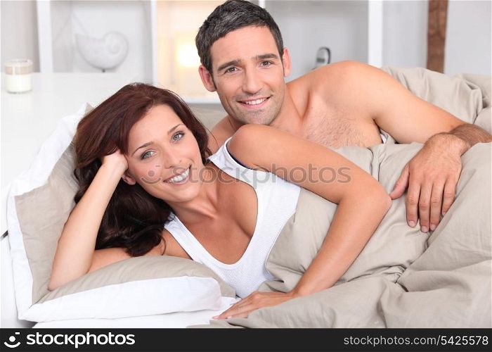 a couple reposing in bed in the morning