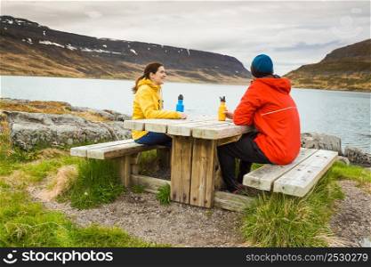 A couple resting close to a beautiful lake