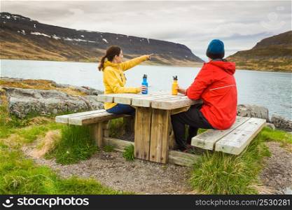 A couple resting close to a beautiful lake
