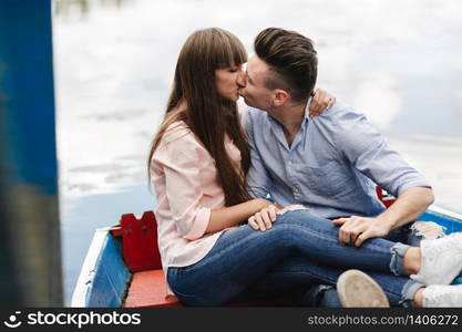 A couple riding a blue boat on a lake. romance. emotional couple. A couple riding a blue boat on a lake. romance. emotional couple. funny and in love