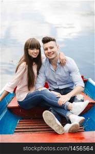 A couple riding a blue boat on a lake. romance. emotional couple. A couple riding a blue boat on a lake. romance. emotional couple. funny and in love