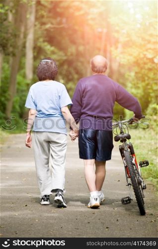 A couple senior asian talking while walking and exercising at a park