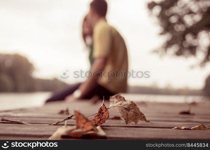 a couple sitting by the water and hugging