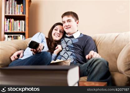 A couple sitting on sofa and watching television