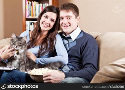 A couple sitting on sofa relaxing at home