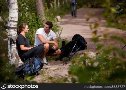 A couple take a break while backpacking on a prepared trail