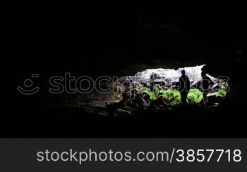 A couple ventures into a lava tube with flash lights in Hawaii