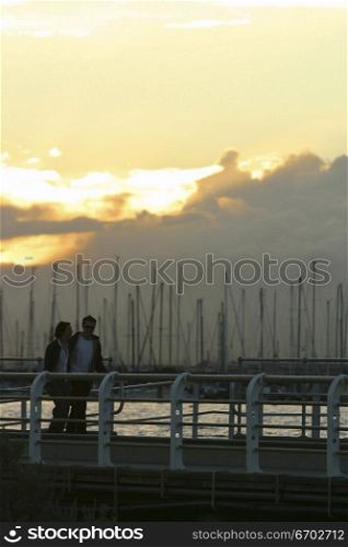 A couple walk along a Pier in St. Kilda. May 2003