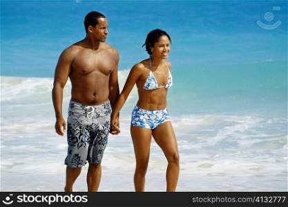 A couple walking near a seashore, Natural Arches Beach, Bahamas