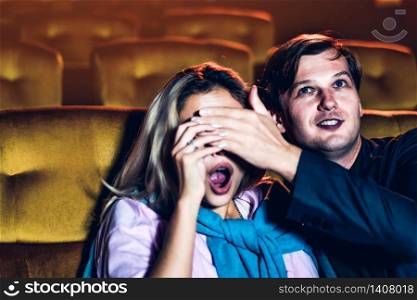 A couple watching a thriller movie in the cinema, Men use their hands to close his girlfriend&rsquo;s eyes.