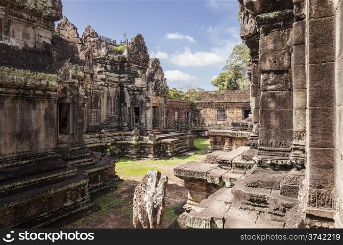 A courtyard in the Banteay Samre temple near Angkor Wat in Cambodia. The temple buildings are located on both sides of the green space.