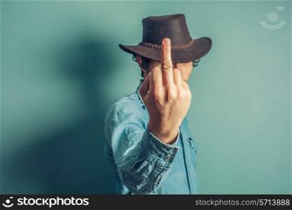 A cowboy is displaying an obscene gesture