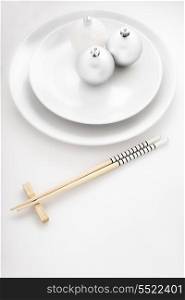 A creative plate in a japanese sushi restaurant menu decorated with Christmas balls and chopsticks.