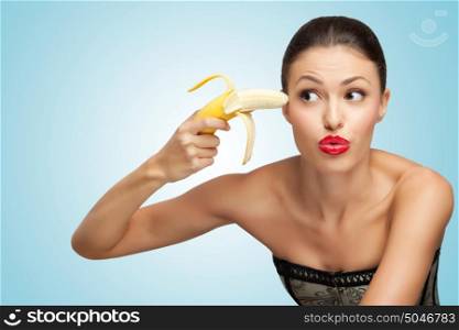A creative portrait of a beautiful girl trying to shoot herself with a banana gun.