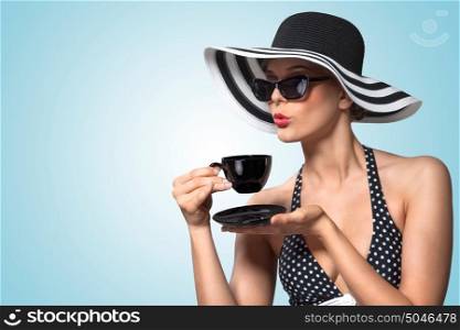 A creative vintage photo of a beautiful pin-up girl drinking tea and showing good table manners.