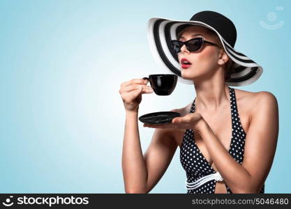 A creative vintage photo of a beautiful pin-up girl drinking tea and showing good table manners.