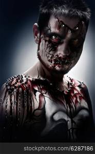 A creepy portrait of a pierced halloween moor with bloody body art.