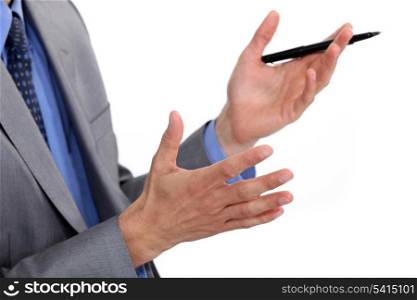 A cropped picture of a businessman holding a pen.