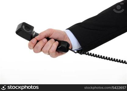 A cropped picture of a businessman holding landline phone.