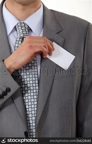 A cropped picture of a businessman putting his card in his pocket.
