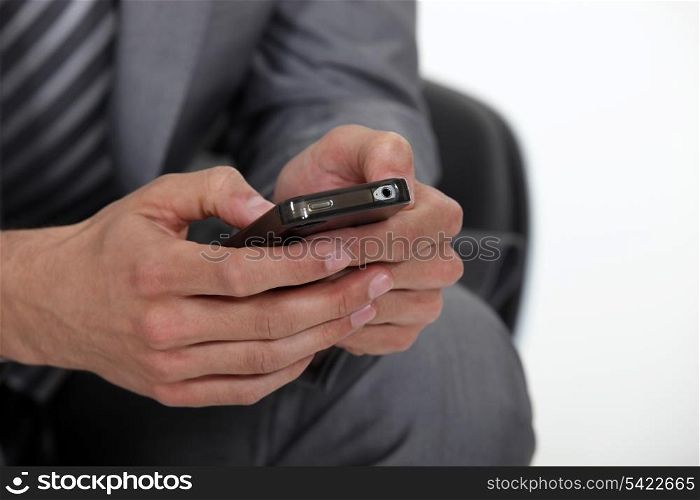 A cropped picture of a businessman texting.