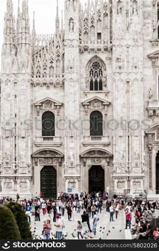 A crowd of people move around in front of the Cathedral of Milan, of whom most are tourists coming to view the 5th largest church in the world.