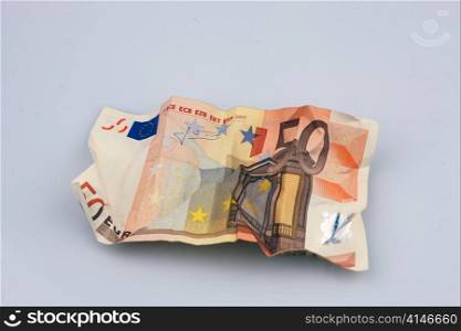 a crumpled euro note. symbolic photo for the debts and taxes.