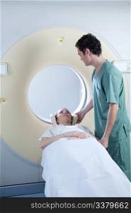 A CT scan machine with patient and nurse