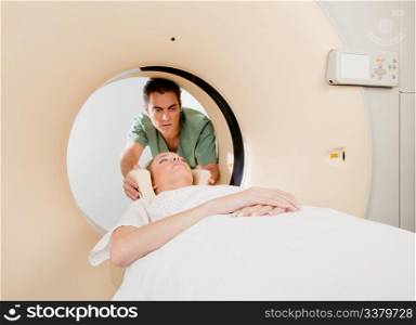 A CT scan technician aligning a patient in the machine