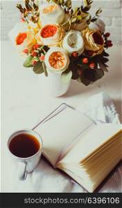 A cup of black tea, notebook and beautiful flowers on the table. Morning inspiration for the day planning. Inspiration for solving difficult problems