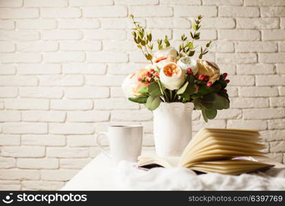 A cup of black tea, notebook and beautiful flowers on the table. Morning inspiration for the day planning. Inspiration for solving difficult problems