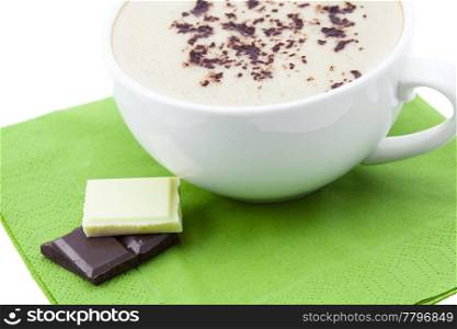 a cup of cappuccino and chocolate on a napkin