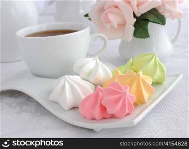 A cup of coffee and biscuits meringue on a plate closeup