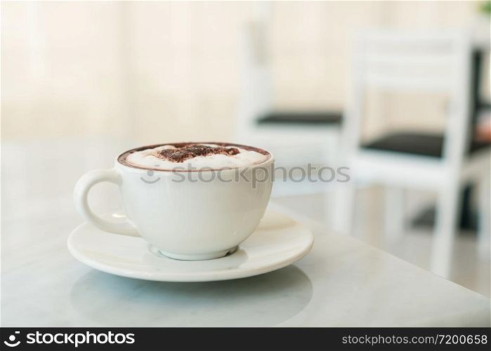 A cup of coffee on marble table in cafe.