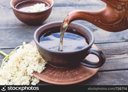 a cup of Elderflower tea with fresh flowers. Healthy Medicine Elderberry Flower Tea. a cup of Elderflower tea with fresh flowers