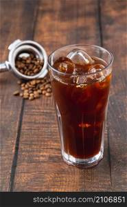 A cup of Iced Americano Coffee with ice cubes placed on a wooden table in a coffee shop. Top view of a glass of coffee