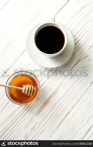 a cup of instant coffee and honey on a white textured wooden background top view, cozy and delicious breakfast. Rustic background. a cup of instant coffee and honey on a white textured wooden background top view, cozy and delicious breakfast. Rustic background, vertical image