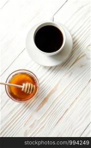 a cup of instant coffee and honey on a white textured wooden background top view, cozy and delicious breakfast. Rustic background. a cup of instant coffee and honey on a white textured wooden background top view, cozy and delicious breakfast. Rustic background, vertical image