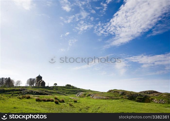 A curch on a hill and a green meadow